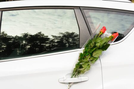 Bouquet of roses in a car doorの写真素材