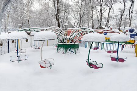 Snow covered carousel in a city park at winter の写真素材
