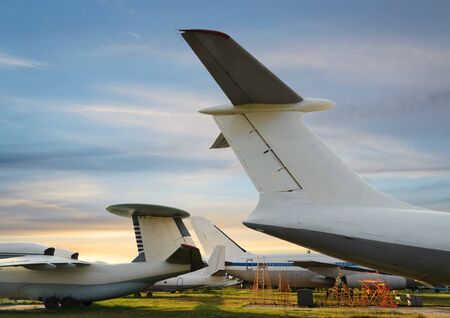 Rear parts with tails of large aircraft in the parking lot at sunset の写真素材