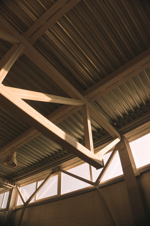 Interior of a modern building with wooden beams and a roof.の写真素材
