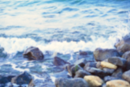 Strong sea wave splashing on the rocky shores; blurred backgroundの写真素材