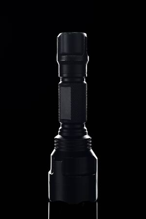 Black pocket hand flashlight isolated, shiny silhouetteの写真素材