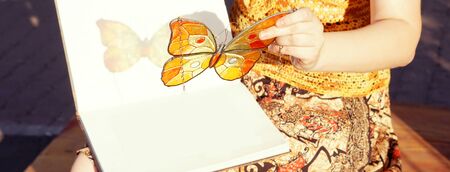 Handmade stained glass butterfly in woman's hands, cover template for social networksの写真素材