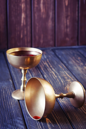 Two antique golden goblets with red wine; selective focusの写真素材