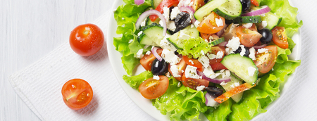Fresh vegetable Greek salad with oil bottle, white background, cover template for social networksの写真素材