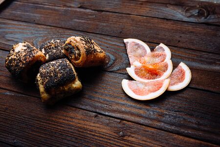 Sweet buns with poppy seeds, on a wooden table. Grapefruit Slices.の写真素材