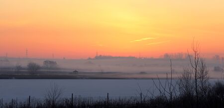 snow covered lake in the morning mistの写真素材