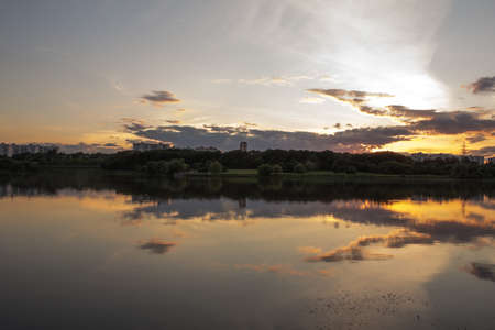 lake landscape with cloud reflections, golden downの写真素材