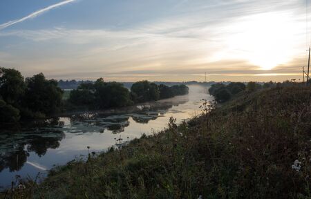 Sunrise over a misty river on a summer morning
