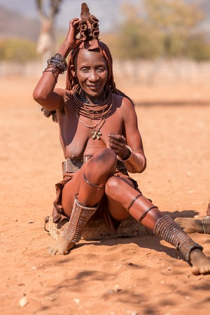 EPUPA, NAMIBIA - AUGUST 4: An unidentified Himba woman smiles while tourists visit the the settlement on August 4, 2013 in Namibiaのeditorial素材
