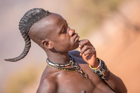 EPUPA, NAMIBIA - AUGUST 4: An unidentified Himba man standing while tourists visit the the settlement on August 4, 2013 in Namibiaのeditorial素材