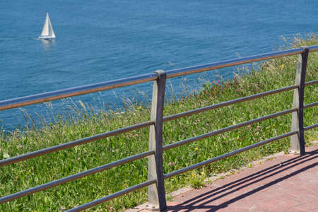 Side view of Fence to the ocean and sailing ship, Focus on fenceの写真素材