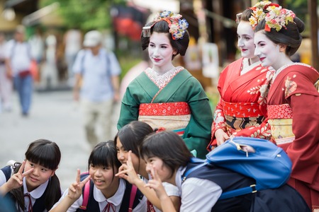 KYOTO, JAPAN - JUNE 10: Unidentified tourist women dress like a Maiko and take photo with children, Tourists usually makeup as Geishas (also known as Maiko) in Kyoto on June 10, 2015 in Japanのeditorial素材