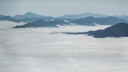 Detailed view of beautiful clouds and fog below mountain summitsの写真素材