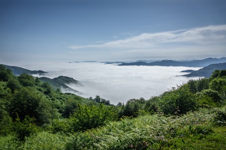 Detailed view of beautiful clouds and fog below mountain summits and covering valleyの写真素材
