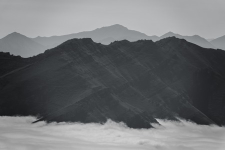 Detailed view of beautiful clouds and fog below mountain rangeの写真素材