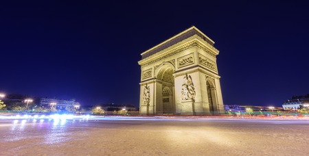 Night time in Arc de Triomphe and blurred cars traffic along the traffic circleの写真素材