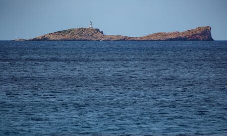 Lighthouse on top of rock islandの写真素材