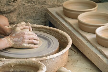 Young woman hands working on pottery wheel