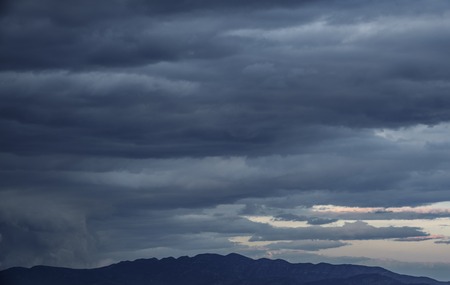 Cloudy sky, dark clouds, close storm over mountain range
