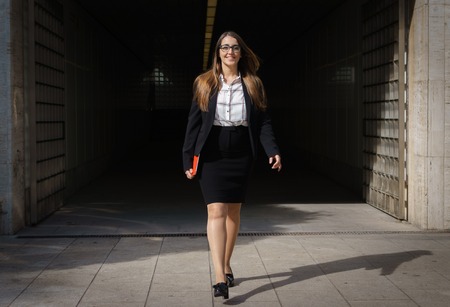 Woman walks out of tunnel with tablet pc smilingの写真素材