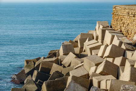 Huge concrete cubes forming a breakwater against oceanの写真素材
