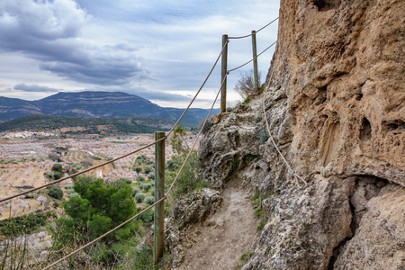 Steep track over the vertical rock with protection ropesの写真素材