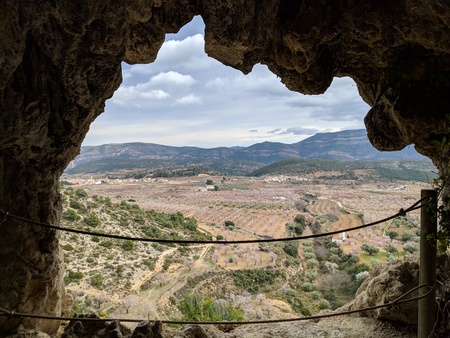 Almond tree bloom in thevalley from inside of the caveの写真素材