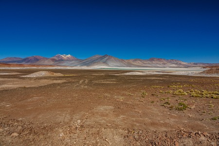 Red stones and Talar salar in Atacamaの写真素材