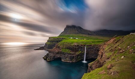 Gasadalur waterfall wide long exposure in Faroe Islands, misty dayの写真素材