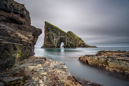 Amazing ultra wide angle long exposure of Drangarnir gate in front of Tindholmur, Faroe Islandsの写真素材