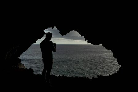 Hole to the pacific ocean inside lava cave with tourist