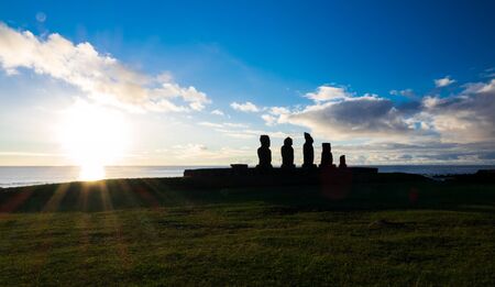 Moais in Ahu Tahai at sunset with sun in the horizonの写真素材