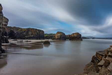 Long exposure in cathedral beach with blurred touristsの写真素材