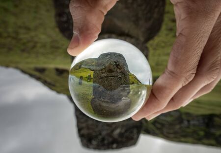 Hand holding glass with Moai statueの素材 [FY310136253500]