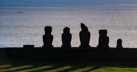 Ahu tahai moai platform at sunset against the oceanの写真素材