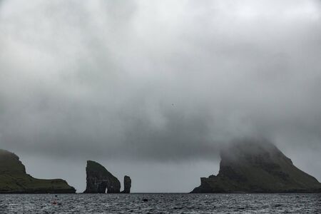 Drangarnir gate, Tindholmur and typical sky in Faroe Islandsの写真素材