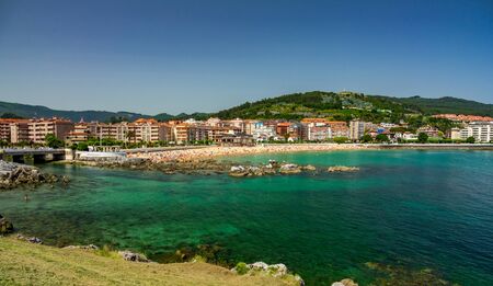 Castro Urdiales city and beach with many bathers at summerの写真素材