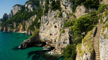 Stairs to the cliff near bright oceanの写真素材