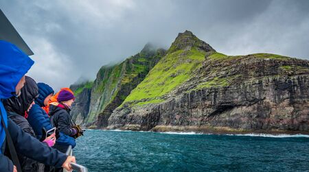Unidentified tourists enjoy de magneficent view of vestmanna cliffsのeditorial素材