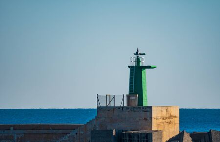 Green painted lighthouse over concrete and clear skyの写真素材