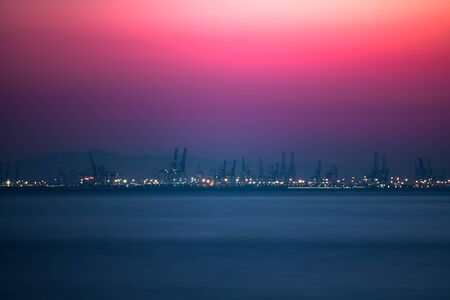 Pink sunset over the commercial dock with cranesの写真素材