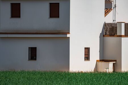 White house with sun and shadow near onion fieldの写真素材