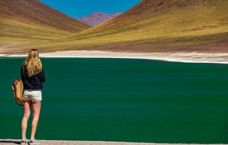 Rear view of unrecognizable tourist woman in the highlands lakes of Atacamaの写真素材