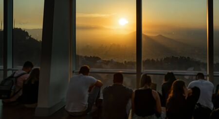 Rear view of unrecognizable people looking at sunsetの写真素材