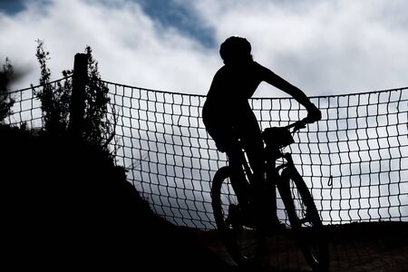 Front view of mountain biker silhouette in a curve with netの写真素材