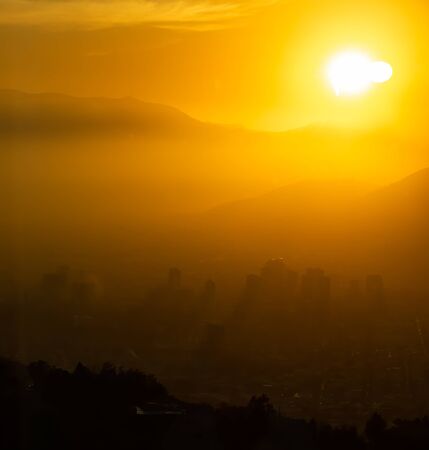 Bright orange sunset over the city silhouetteの写真素材