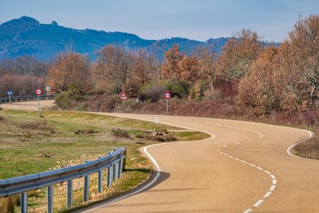 Curved road towards the mountain rangeの写真素材