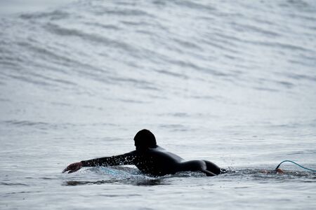Unrecognizable surfer searching for the next wave
