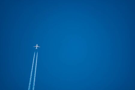 Jet plane trail crossing the sky from bottom left to upper sideの写真素材